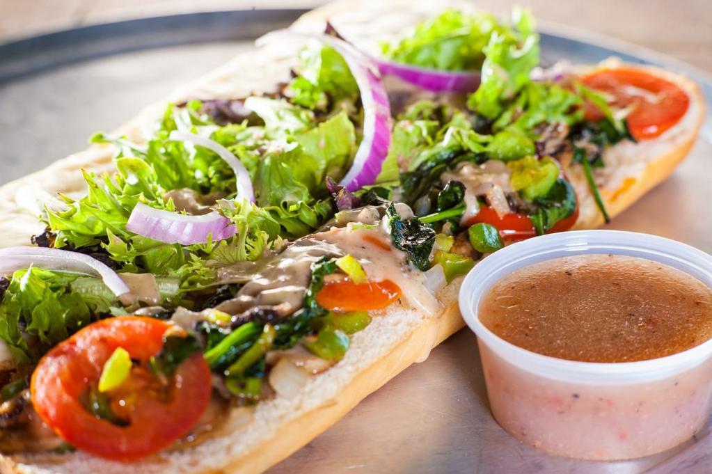 Veggie Hero · Provolone and mozzarella cheese melted over sauteed mushrooms, onions, and bell peppers, spinach and tomatoes, topped with fresh greens and housemade vinaigrette.
