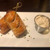 Bangers In A Blanket · Irish sausage rolled in puff pastry topped with chives and sesame seeds. Served with creamy ...