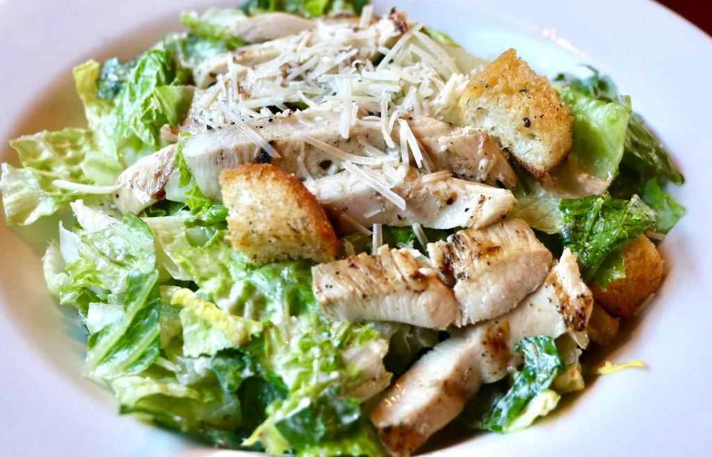 Grilled Chicken Caesar Salad · Romaine hearts, Parmesan cheese and housemade Caesar dressing topped with grilled chicken and house-made croutons.