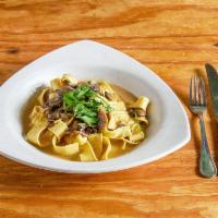Pappardelle ai Funghi · Homemade ribbon pasta with wild mushrooms and black truffle sauce.