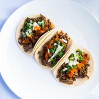 Taco · Small corn tortilla, onions, cilantro, and hot sauce.