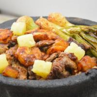 Molcajete Tapatio Fajita Dinner · A hot stone bowl filled with rib eye steak, chicken, shrimp, poblano peppers, onions, chunks...