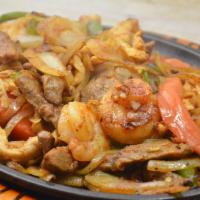 Texas Fajitas Dinner · Tender beef, chicken and shrimp cooking with onion, tomatoes and bell peppers, guacamole sal...