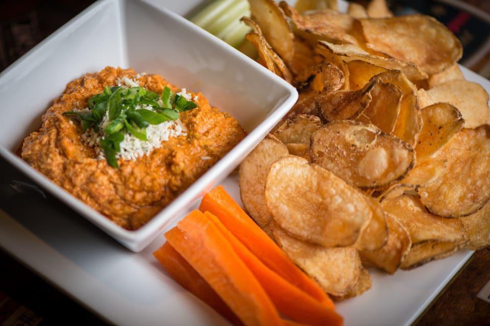 Buffalo Chicken Dip · Shredded Buffalo chicken, cheddar, bleu cheese crumbles, green onions, chips and veggies. Spicy.