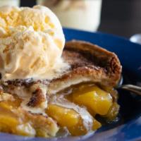 Peach Cobbler · Peaches in a flaky crust, served with a scoop of vanilla ice cream.
