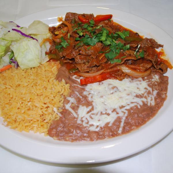Steak a la Chicana · Grilled beef mixed with tomato, onions, bell pepper and homemade sauce. Served with rice, beans and tortillas.