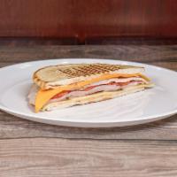 Smoked Turkey and Ham Panini · With Swiss cheese, cheddar cheese, tomatoes, pickles and Creole mayonnaise.  