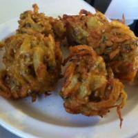 Onion Bhajia · Fried onion fritters battered with rice and chickpea flour.