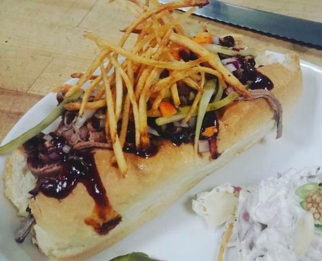 Brisket Dog  · Smoked Gastros kielbasa with shredded Brisket topped with red onion, julienne house pickles and fried potato strings, BBQ sauce, mustard and a side of slaw. 