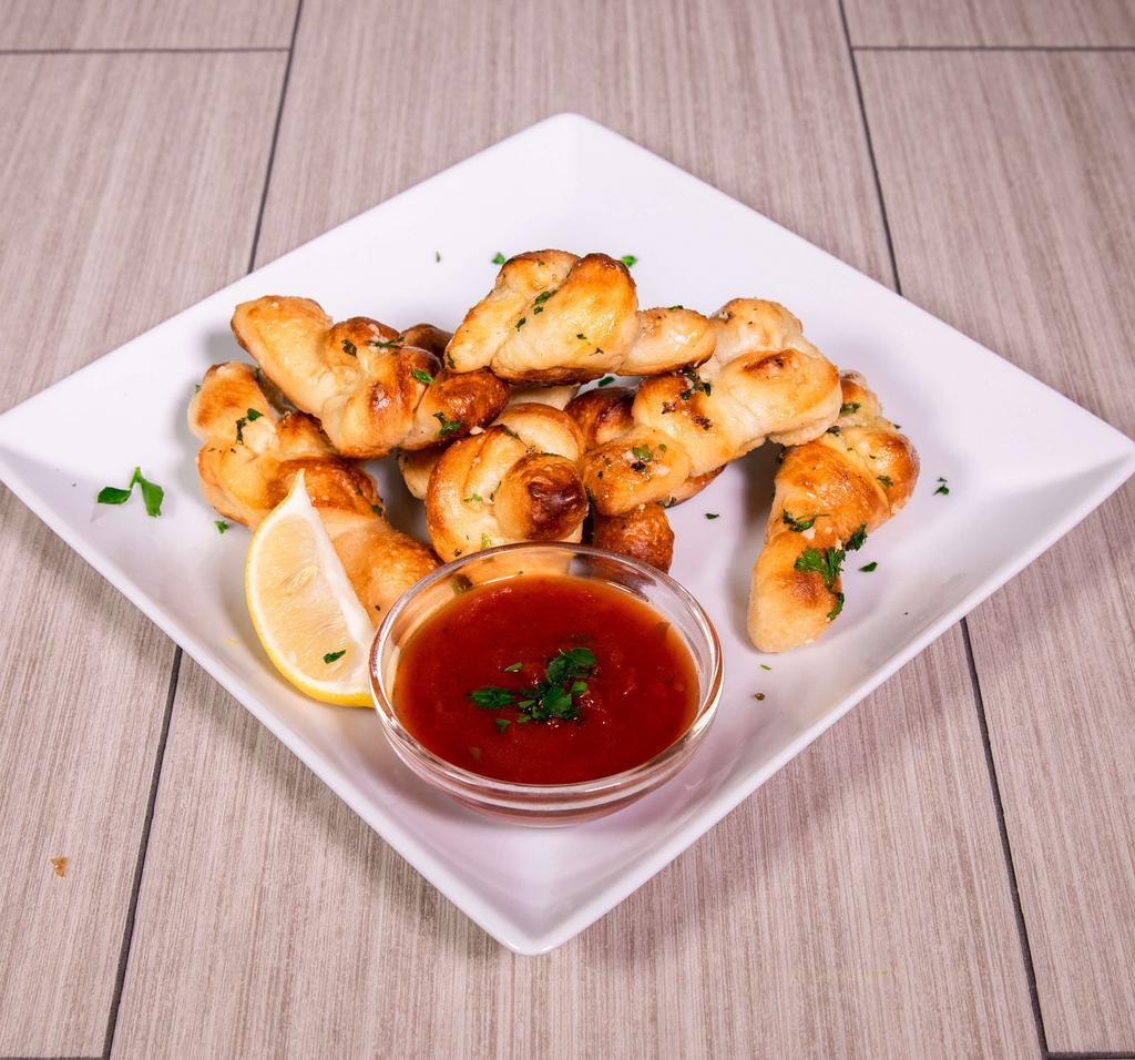 Truffle Garlic Knots · Hand-knotted pizza dough tossed with truffle olive oil, fresh garlic and pecorino Romano cheese. Served with a side of Russo's homemade marinara sauce. 