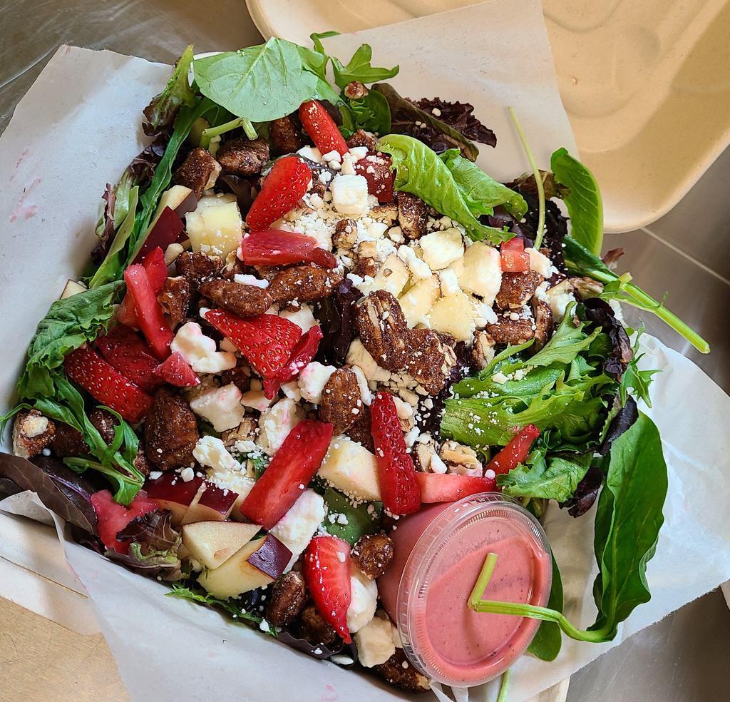 Apple Pecan Salad · Mixed greens tossed with apples, candied pecans, and house made raspberry vinaigrette. Topped with bacon, strawberry, and feta cheese.