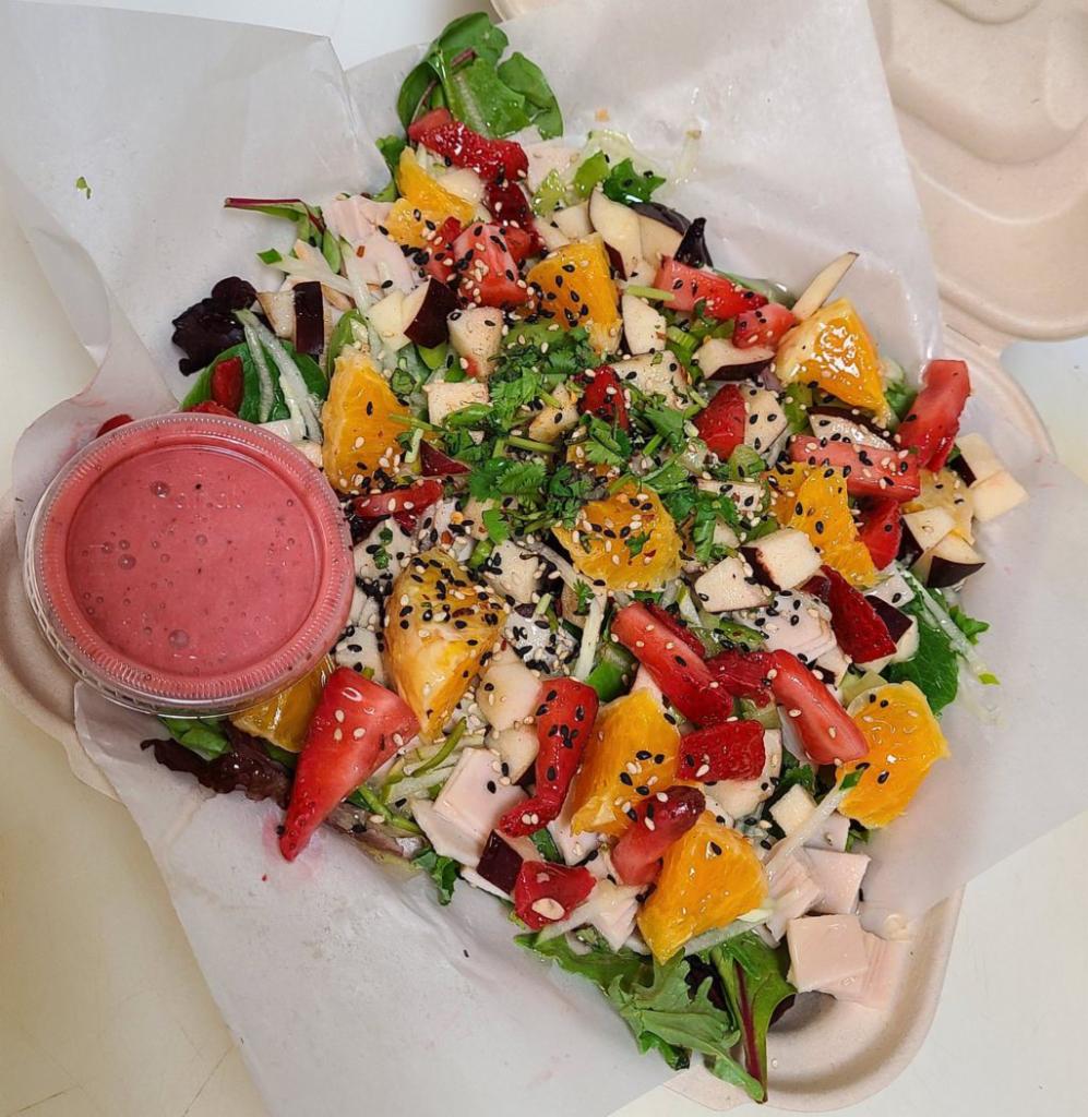 Farm Gone Wild Salad · Mixed greens, tossed with oven roasted turkey, apple, celery, cucumber, and house made raspberry vinaigrette dressing. Topped with bacon, orange, strawberry, sesame seeds, chili flakes, cilantro and honey.