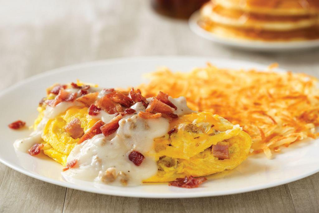Country Music Star Omelette · House-made sausage, diced ham, and onions, topped with cheddar and Monterey Jack cheeses, country sausage gravy and chopped bacon.
