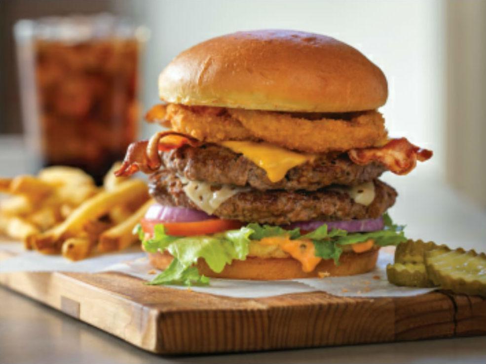 All-World Double Cheeseburger · American and Swiss cheeses on two burger patties topped with two cherrywood-smoked bacon strips, onion rings, and Thousand Island dressing.