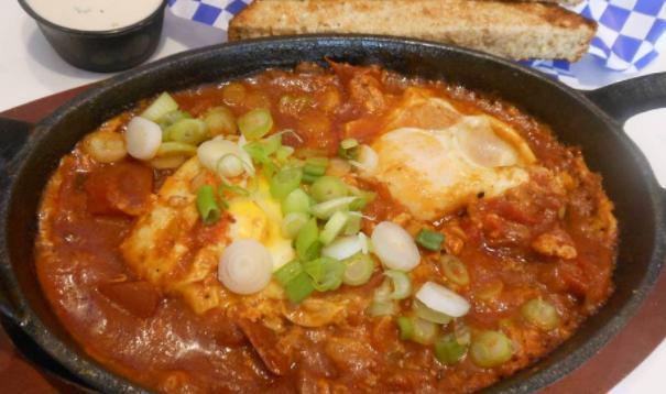 Shakshuka  · Slow cook of tomatoes, jalapenos, garlic, feta served with 2 eggs sunny side up, parsley and sliced 9 grain toasted. 