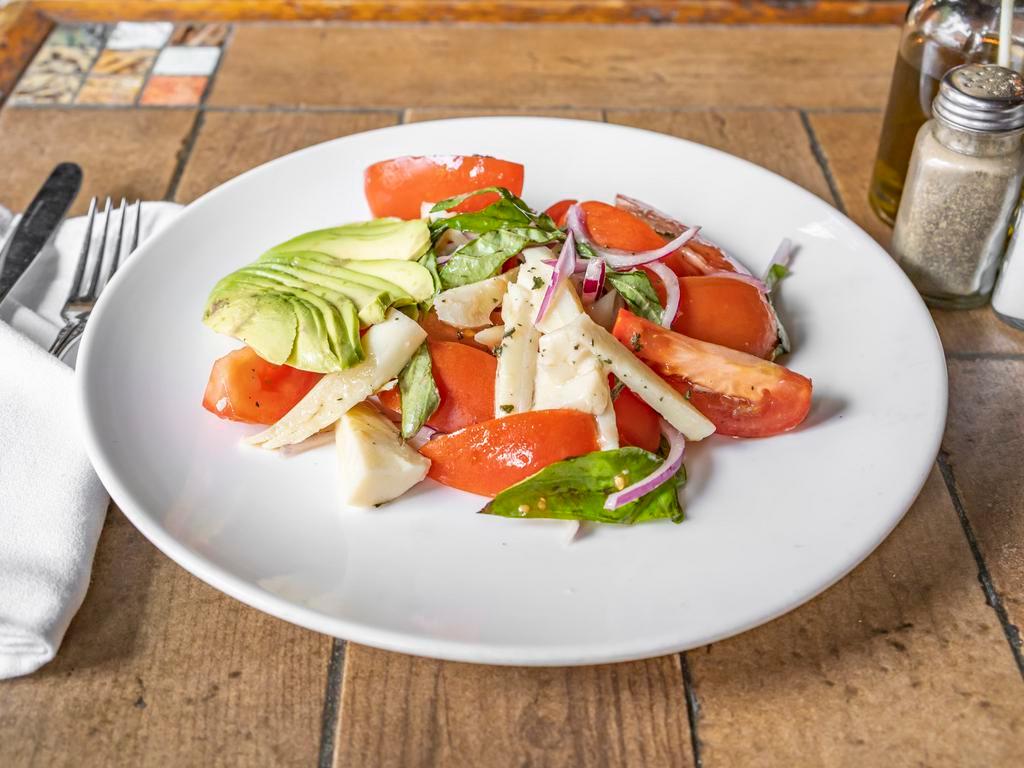 Insalata di Pomodoro · Wedge plum tomato, hearts of palm, Bermuda onion, basil and avocado in extra virgin olive oil. Dressing served on the side.