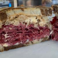 Reuben Sandwich · Thinly sliced corned beef, fresh raw sauerkraut, 1,000 island dressing and  melted Monterrey...