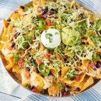 Knock-Out Nachos · Crisp tortilla chips with white cheddar queso & melted cheese blend. Topped with pico de gal...