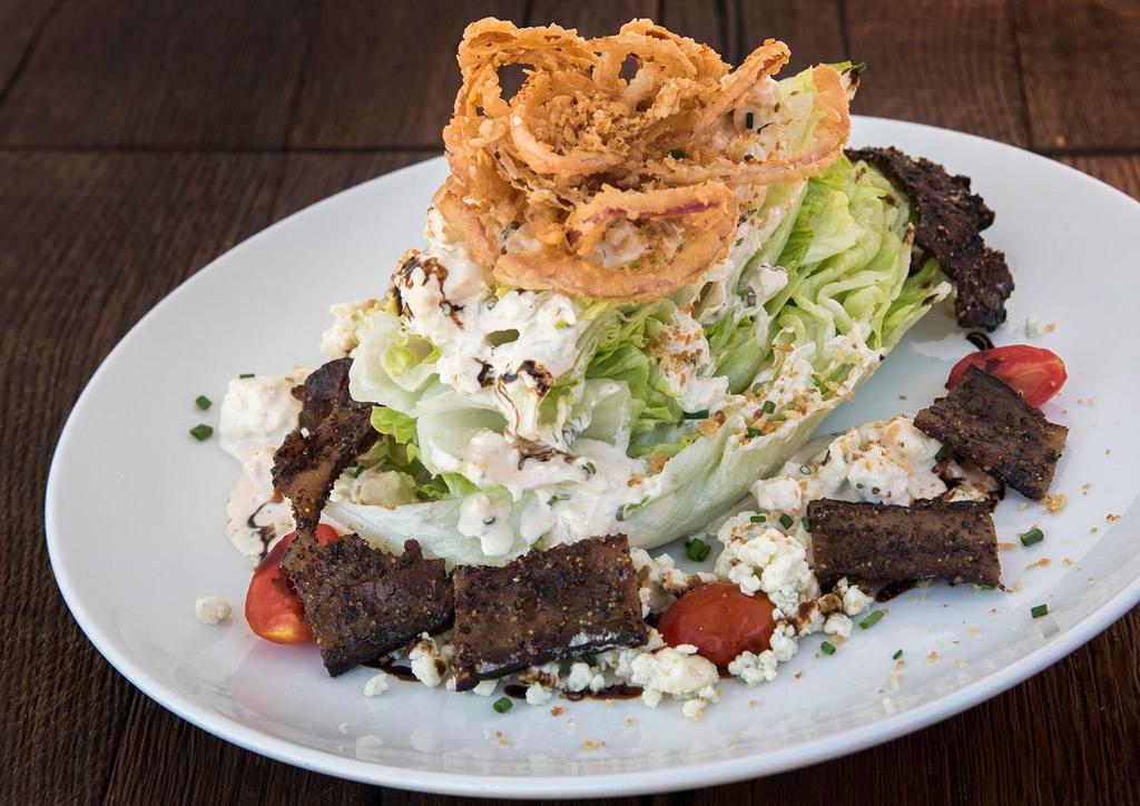 Wedge Salad · Hardwood smoked bacon, tomatoes, blue cheese crumbles, crispy cabbage, blue cheese dressing and balsamic glaze.