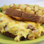 Zesty Smokehouse  · Bacon, sausage and ham folded into scrambled eggs and topped with a blend of Monterey Jack and Cheddar cheeses. Served on our thick wheat toast with chipotle for an extra kick!
