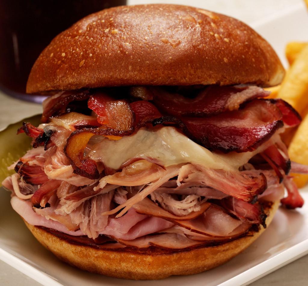 Hog Wild Sandwich · Juicy, tender ham and our famous pulled pork topped with melted provolone cheese and two strips of bacon on a toasted Roma bun.