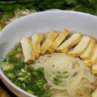 40 - Tofu Pho · Flat rice noodles with tofu in a vegan broth; garnished with yellow onions, scallions, cilan...