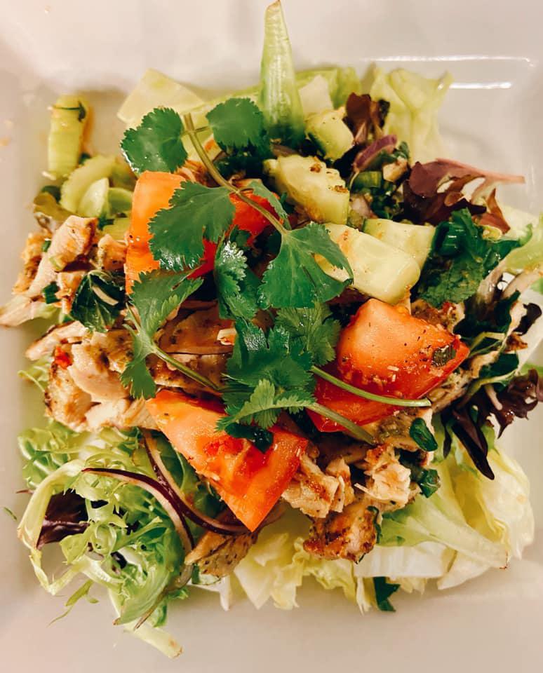 Lemon Grass Chicken Salad · Grilled lemongrass chicken with tomatoes, cucumbers, onions, shallots, affirm lime leaves, mint leaves, cucumber, and fresh lettuce with a touch of spices and lime juice. No substitute.
 