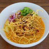 Khao Soi  · Steam egg noodles in curry sauce with your choice of meat on top with crispy egg noodles, ci...