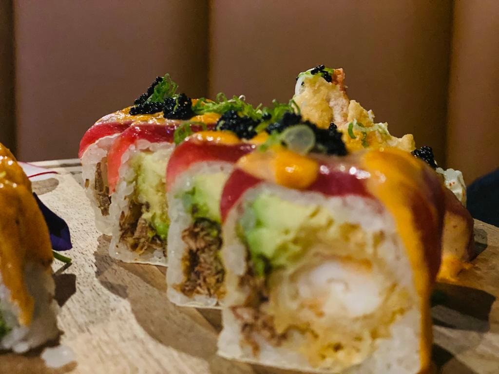 Kissimmee Roll · Lobster tempura, fried onion, avocado roll, wrapped with soy pepper. Seared tuna & spicy mayo, black tobiko&scallion on the top. Raw.