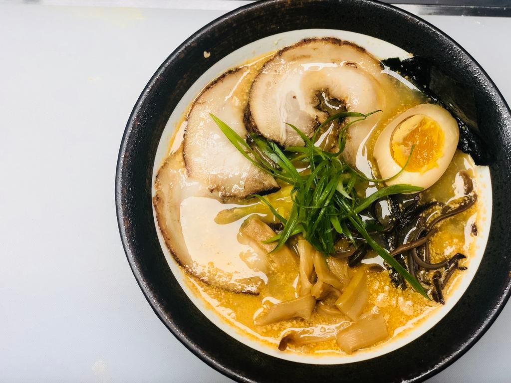 Tonkotsu Ramen · Pork bone broth. Wavy egg noodle. Topped with cashu pork, kikurage mushroom, bamboo shoot, scallion and seasoned boiled egg.