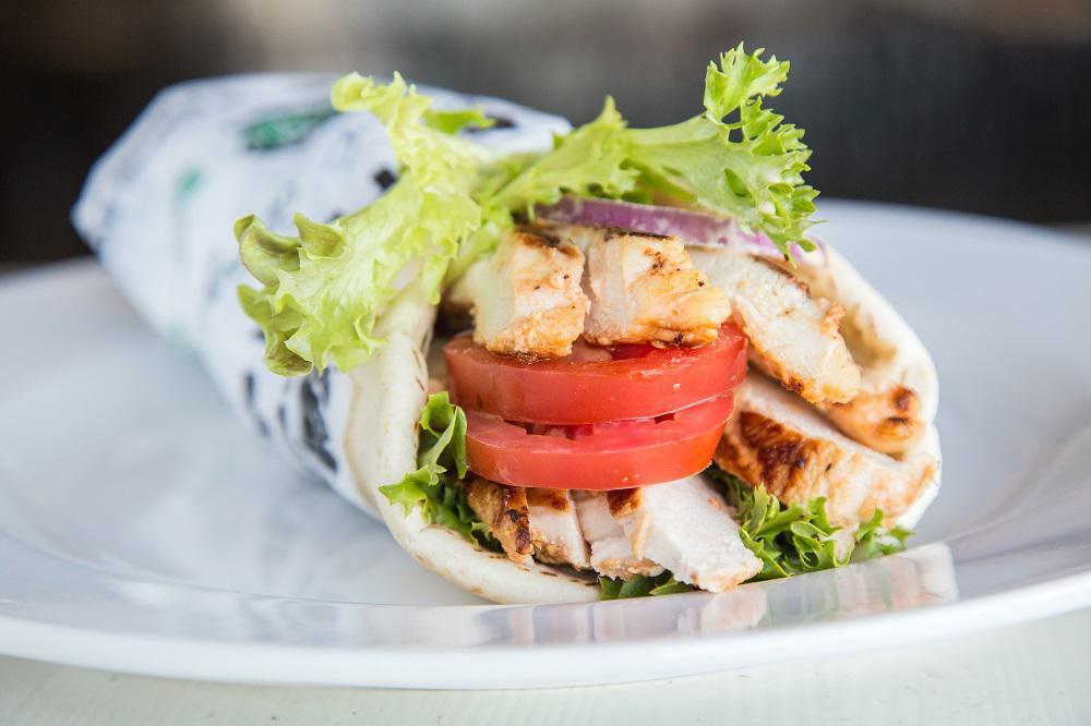 Mediterranean Roasted Chicken Shawarma · grilled marinated all-natural chicken breast, garlic sauce, tahini, seasonal mixed greens, tomatoes, red onions and pickles