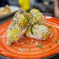 Mexican Street Corn · Fire-roasted corn, crema, Cotija cheese, cilantro, house spices, and lime.