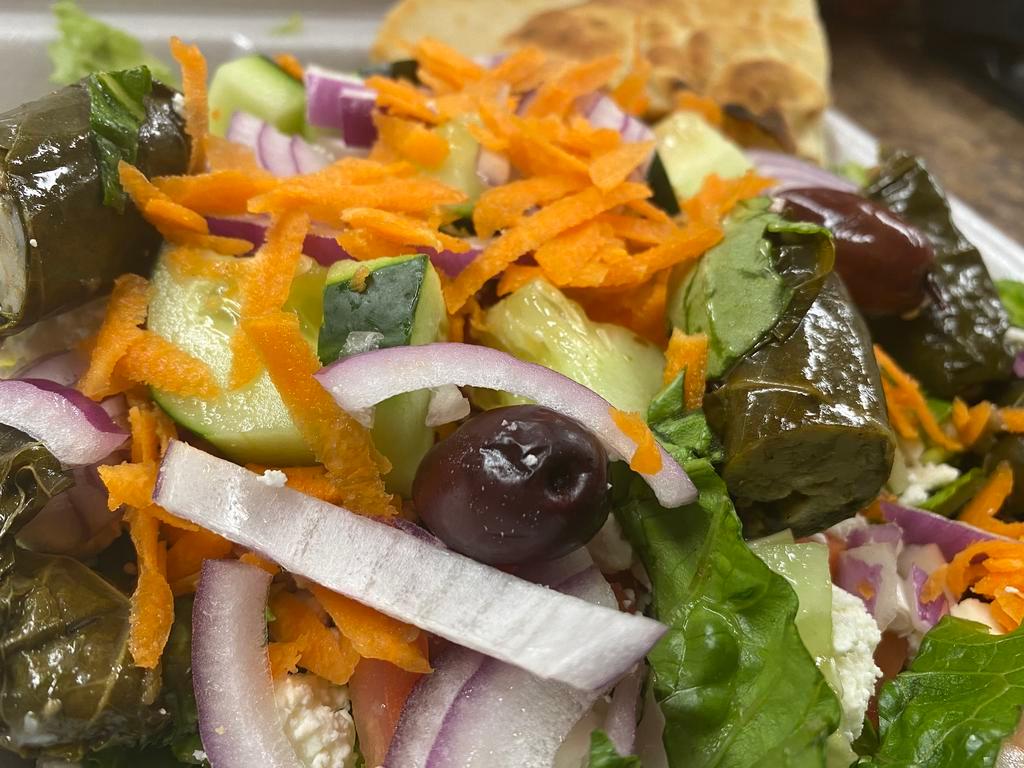 Greek Tavern Salad · Romaine lettuce with tomatoes, cucumbers, red onions, carrots, feta cheese, Kalamata olives and stuffed grape leaves in Greek dressing.