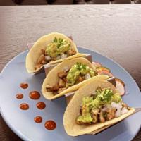 Tacos de Pollo Asado · Three handmade soft corn tortillas topped with grilled chicken, guacamole, onions, and cilan...