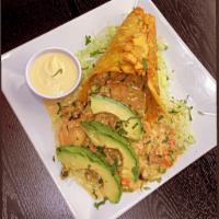 Green Plantain Cone la Pistola · Crispy green plantain cone, filled with calamari rings, octopus, shrimp, peppers, butter and...