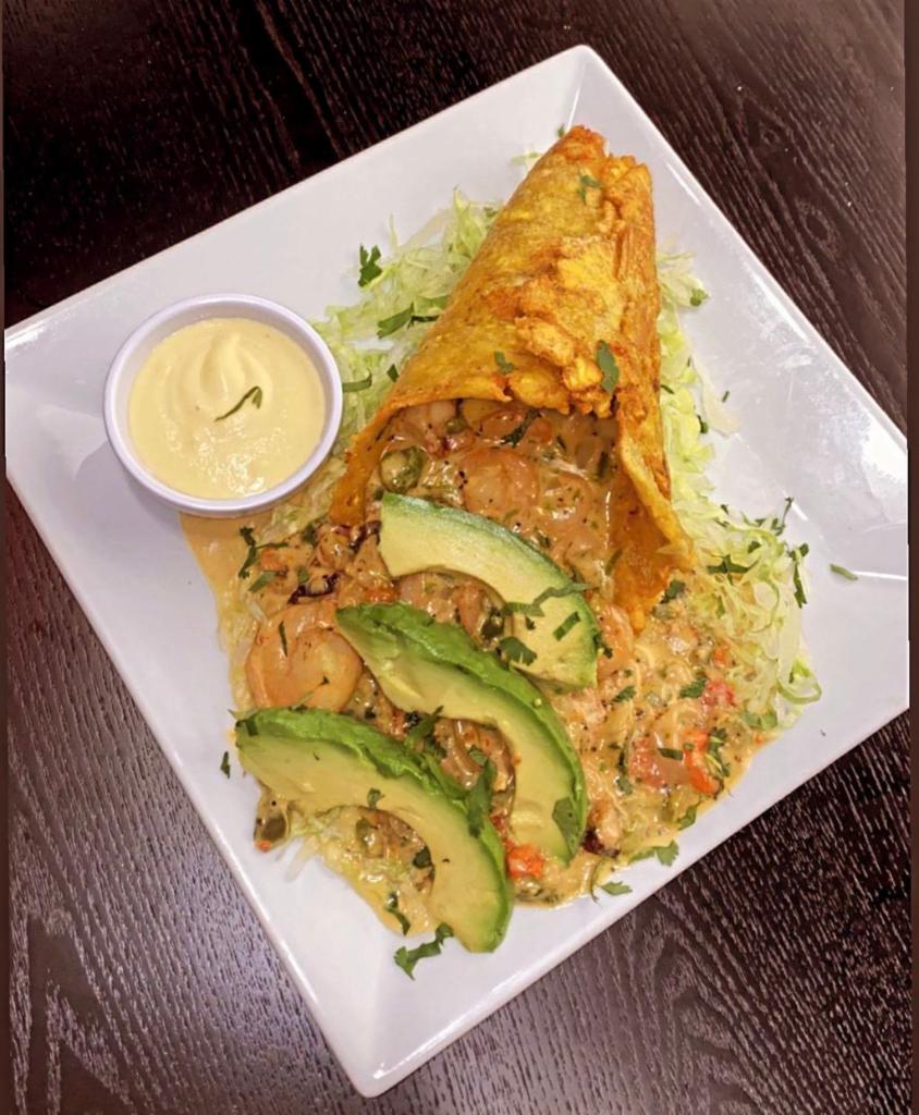 Green Plantain Cone la Pistola · Crispy green plantain cone, filled with calamari rings, octopus, shrimp, peppers, butter and cream. Served with a slice of avocado and passion fruit sauce.