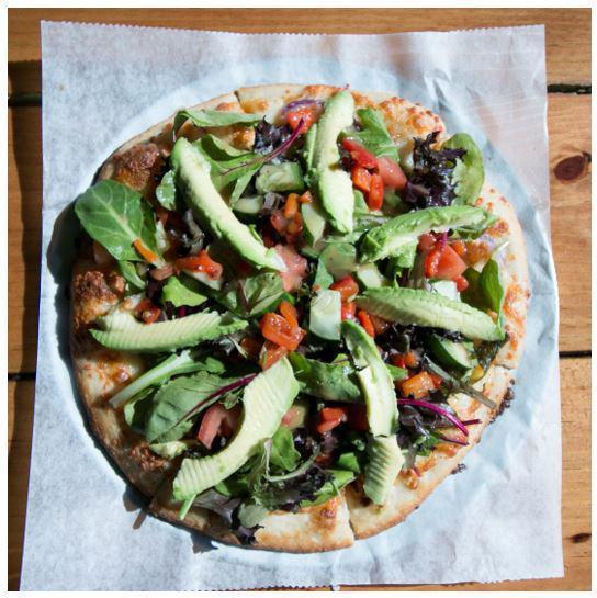 The California Pizza Salad · Mixed greens, cucumber, tomato, grilled chicken, bacon, roasted red pepper, with balsamic or ranch dressing, and avocado on top of a cheese pizza with red onions.