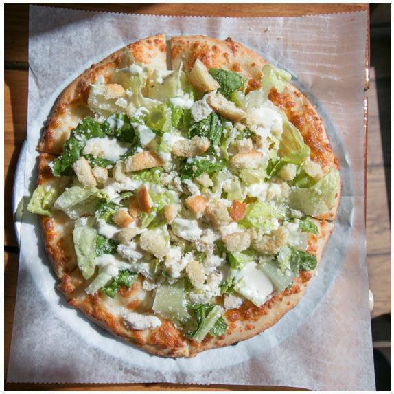 The Grilled Chicken Caesar Pizza Salad · Romaine lettuce, grilled chicken, parmesan cheese, with caesar dressing and croutons on top of a cheese pizza.
