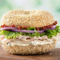 Herby Turkey Sandwich · Roasted turkey, light herb garlic cream cheese, sun-dried tomato spread, lettuce and red oni...