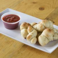 Garlic Knots · 6 pieces.  Comes with a side of red sauce.