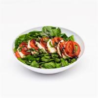 Caprese Salad · Fresh spinach served with fresh mozzarella, roma tomatoes, basil and garlic, topped with cra...