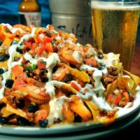 Shrimp and Chorizo Nachos · Grilled shrimp and chorizo topped with corn, black beans, jack and cheddar cheese,
pico and ...