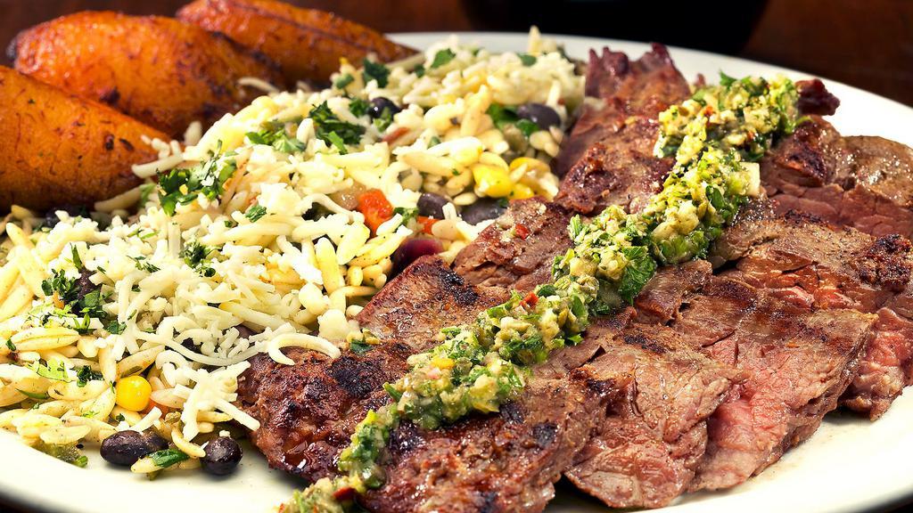 Skirt Steak · Wood-grilled skirt steak topped with our signature salsa verde served with black bean orzo, and fried plantains. (Contains Bacon)
