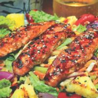 Asian Salmon Salad · Grilled salmon over mixed greens with carrots and cabbage tossed in a ginger dressing topped...