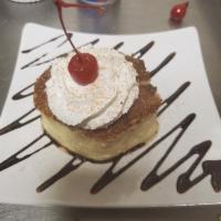 Bread pudding · Delicious house made bread putting topped with whipped cream and chocolate sauce drizzle.