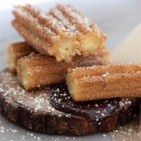 Churros · Deliciously crispy churros covered in cinnamon sugar. Comes with a side of our Chocolate Sau...