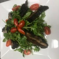 Insalata Portobello · Arugula salad with sliced grilled portobello mushrooms.