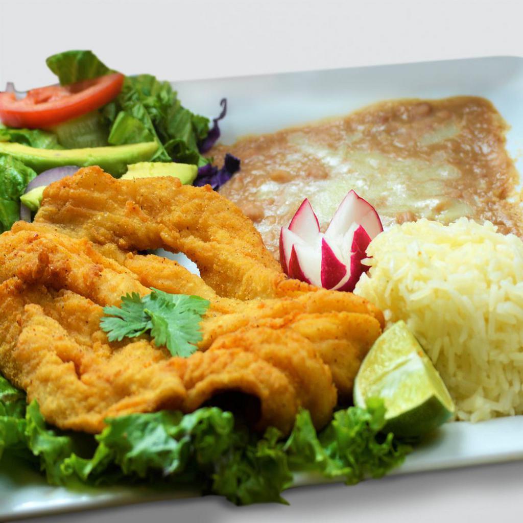 Filette de Pescado · A tender King Basa fillet tossed in flour and fried to golden perfection. The fillet is served with rice, beans, salad, homemade tartar sauce and served with Grandma Lupita's freshly hand-made tortillas.