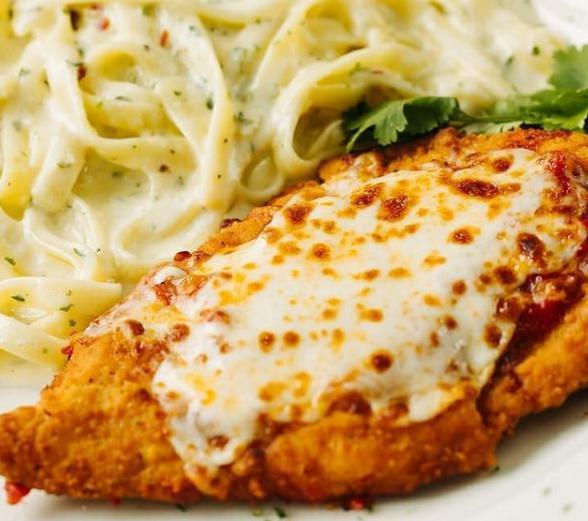 Italian Duo Parmigiana · Our most popular dish! Seasoned and breaded chicken cutlet topped with tomato sauce, house-shredded mozzarella cheese, and served with  a side of creamy fettuccine Alfredo. Served w/tossed salad & bread. 

