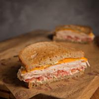 Lighthouse Turkey Cheddar Sandwich · Michigan turkey, cheddar and tomato with pesto mayo on whole wheat bread. Served with a pick...